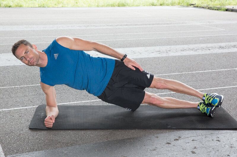Um homem realiza exercícios para perder peso na barriga e nas laterais